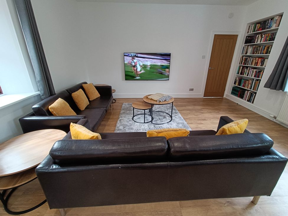A living room with a television and bookshelves at RnB Rural n Beautiful Near Barrhill