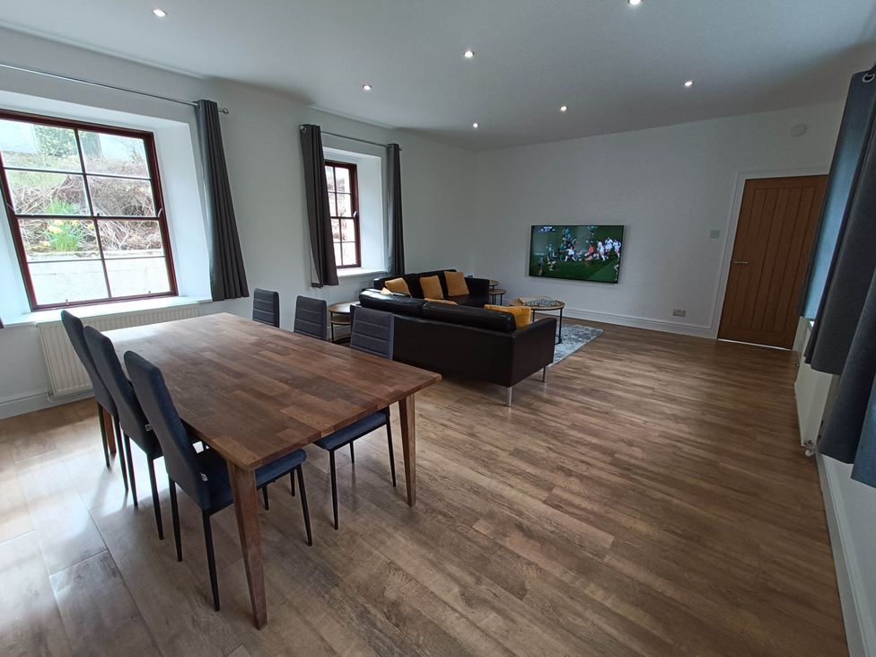 A living room with a table and chairs and a television at RnB Rural n Beautiful Near Barrhill