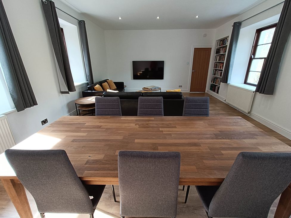 A dining room with a wooden table and chairs at RnB Rural n Beautiful Near Barrhill