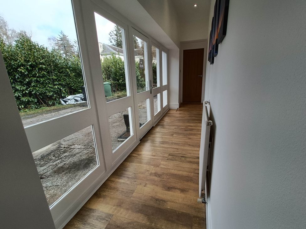 A hallway with windows and a door at RnB Rural n Beautiful near Barrhill