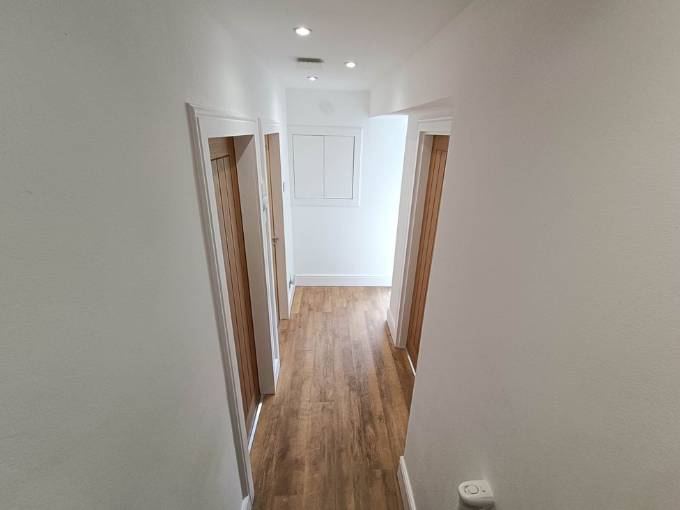 A hallway with doors and wooden flooring at RnB Rural n Beautiful Near Barrhill