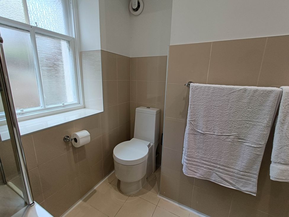 A bathroom with a toilet and towels at RnB Rural n Beautiful near Barrhill