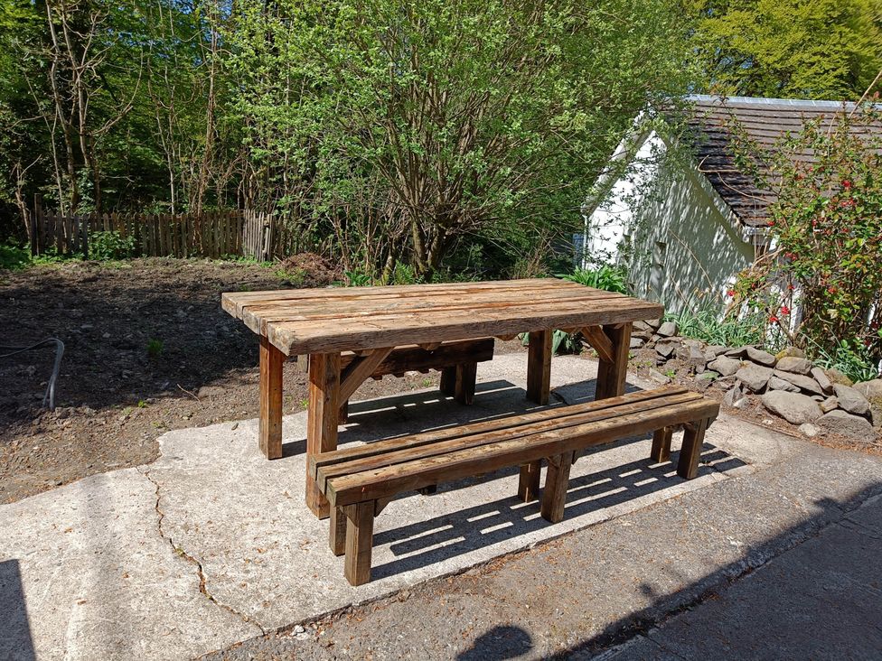A table and benches in an outdoor area at RnB Rural n Beautiful Near Barrhill