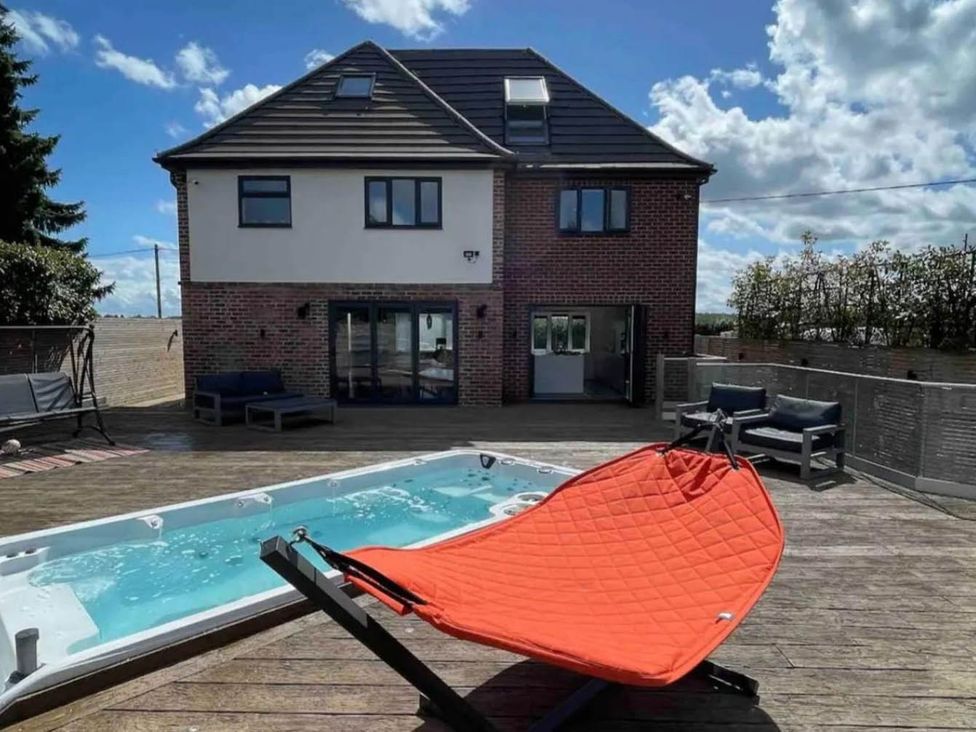 An outdoor area with a hot tub and seating at Hot tub  BBQ  Garden Parking  Sleeps 8 in Worcester