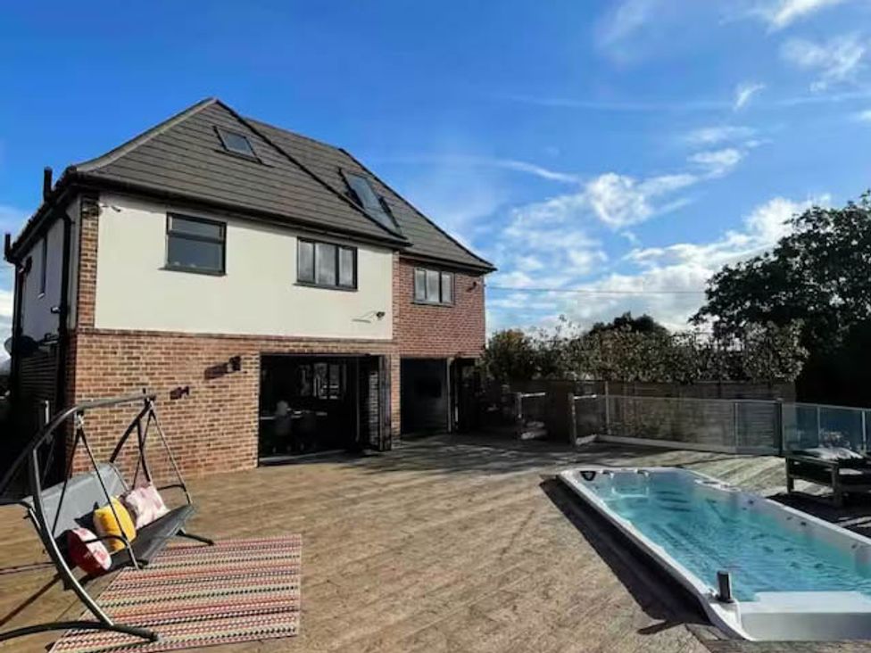 An outdoor area featuring a house, deck, swimming pool, and swing at Hot tub  BBQ  Garden Parking  Sleeps 8 Worcester
