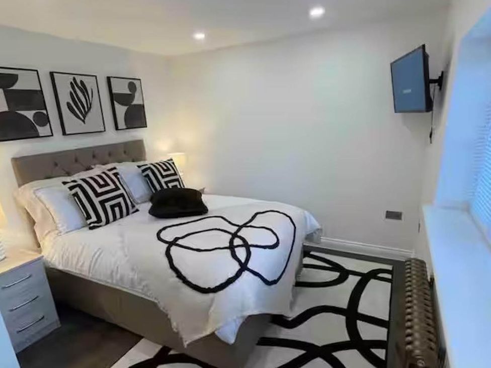A bedroom with a bed and artwork on the wall at Hot tub  BBQ  Garden Parking  Sleeps 8 in Worcester