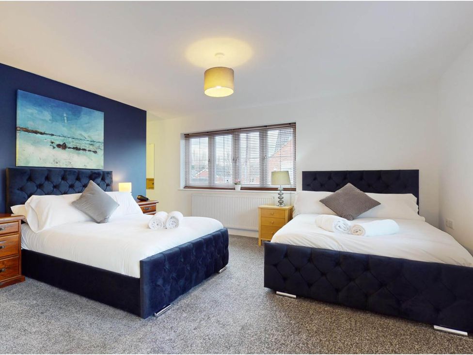 A bedroom with two beds and a lamp at 5 Bedroom Home Sleeps 16 Ideal for Groups in Epworth