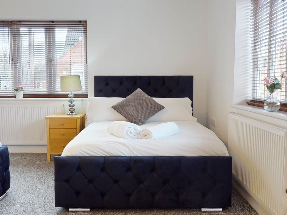 A bedroom with a bed and nightstand at 5 Bedroom Home Sleeps 16 Ideal for Groups in Epworth