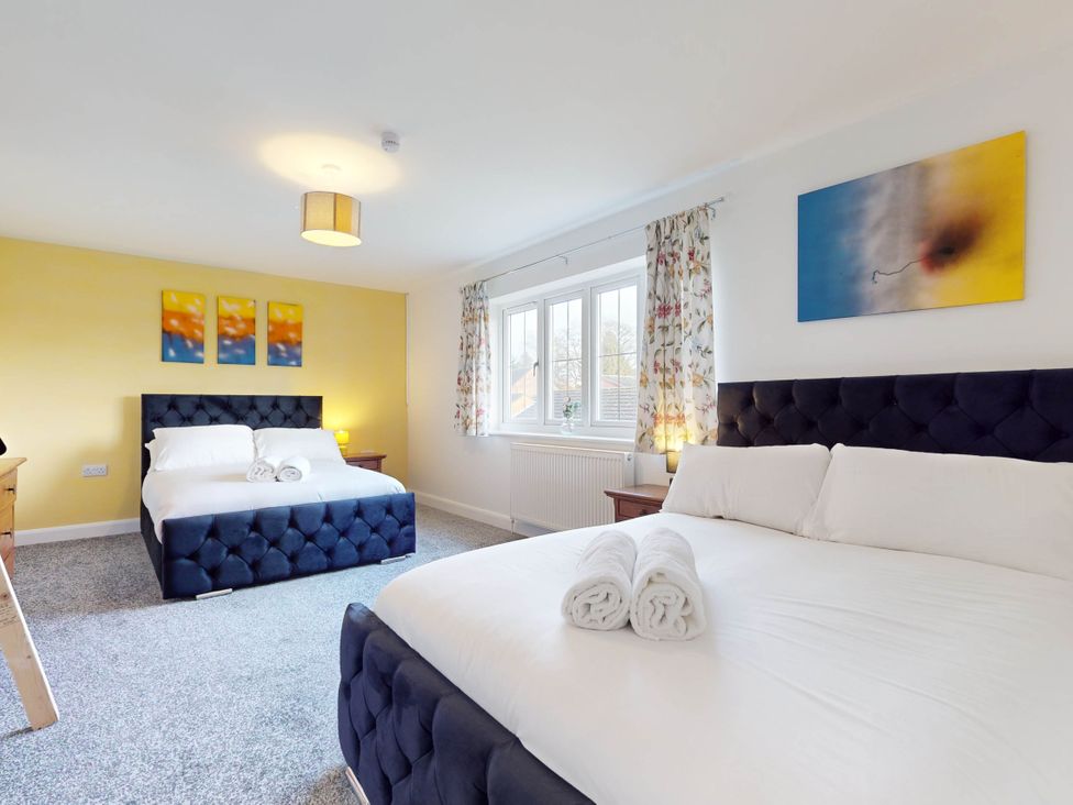 A bedroom with two beds and paintings at 5 Bedroom Home Sleeps 16 Ideal for Groups in Epworth