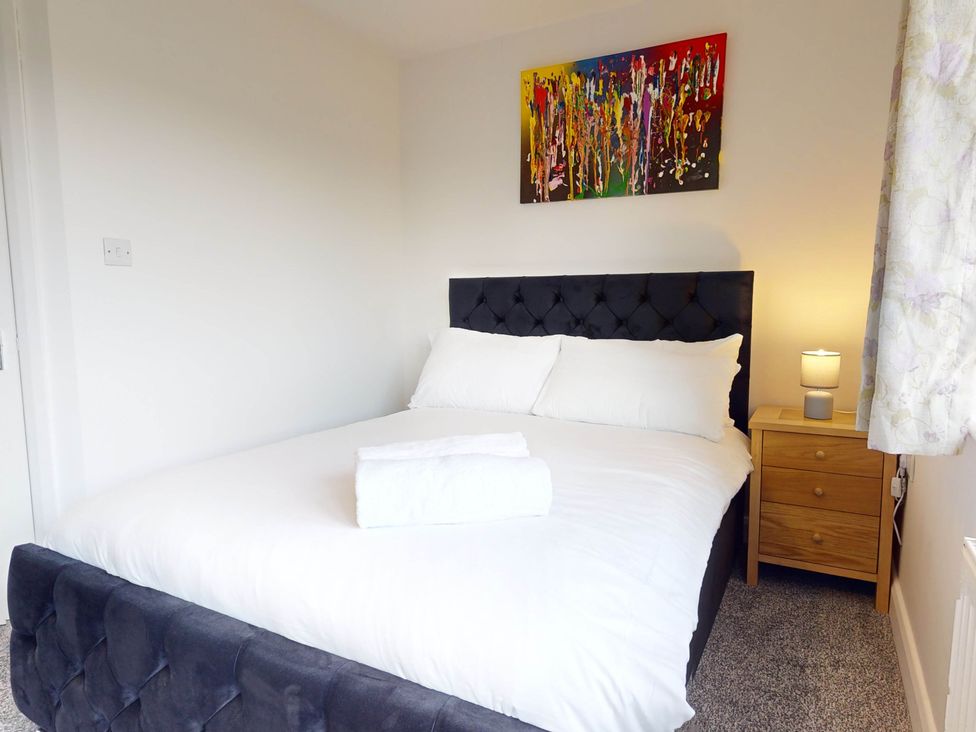 A bedroom with a bed and nightstand at 5 Bedroom Home Sleeps 16 Ideal for Groups, Epworth