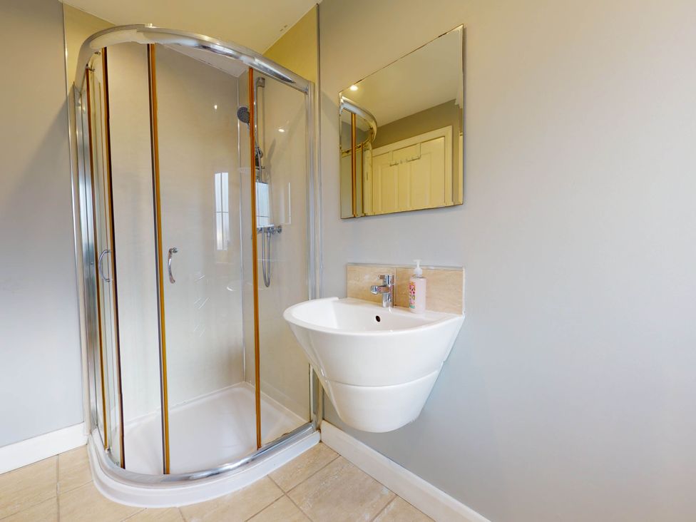 A bathroom with a shower and a wall-mounted sink at 5 Bedroom Home Sleeps 16 Ideal for Groups in Epworth