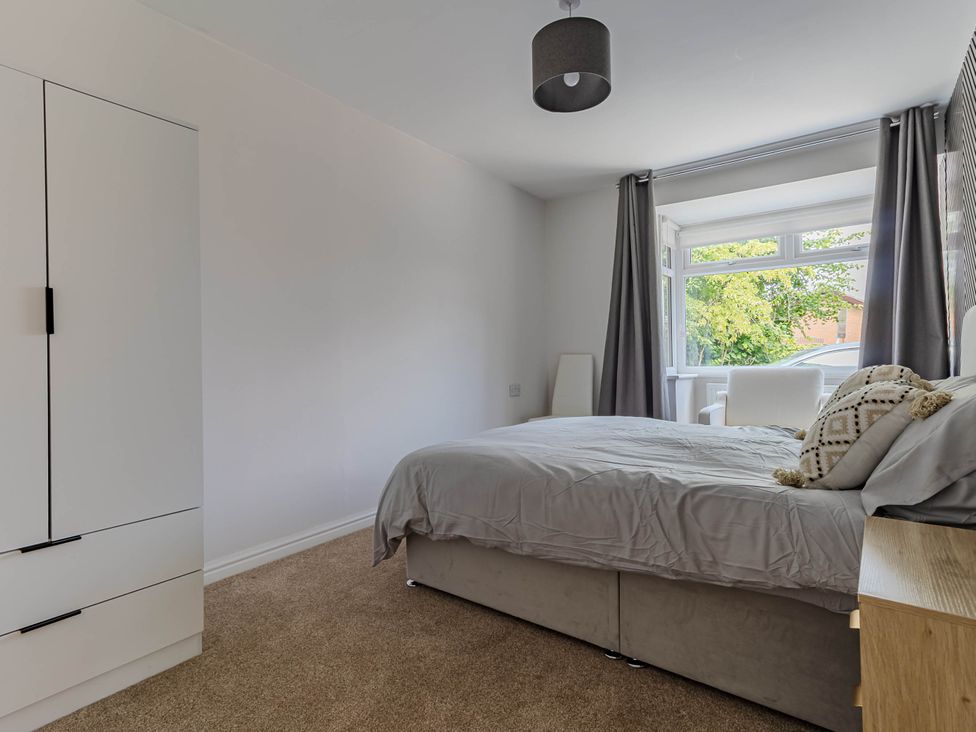 A bedroom with a bed and wardrobe at Loughborough Luxe Bungalow Retreat Sleeps 6 Shepshed