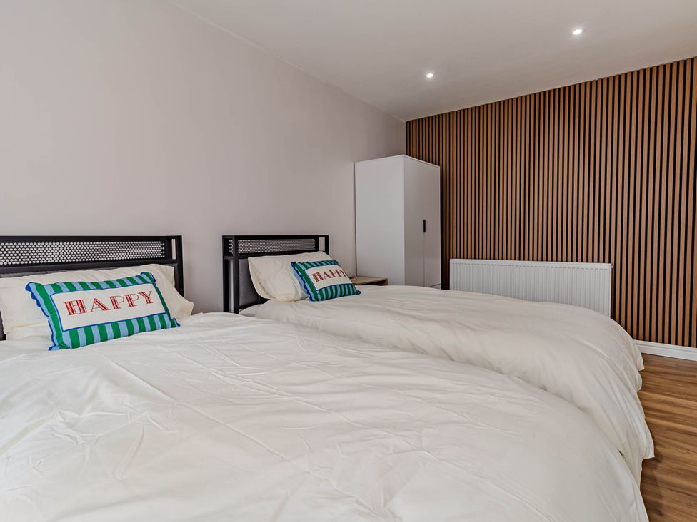 A bedroom with two beds and a wardrobe at Loughborough Luxe Bungalow Retreat Sleeps 6 in Shepshed