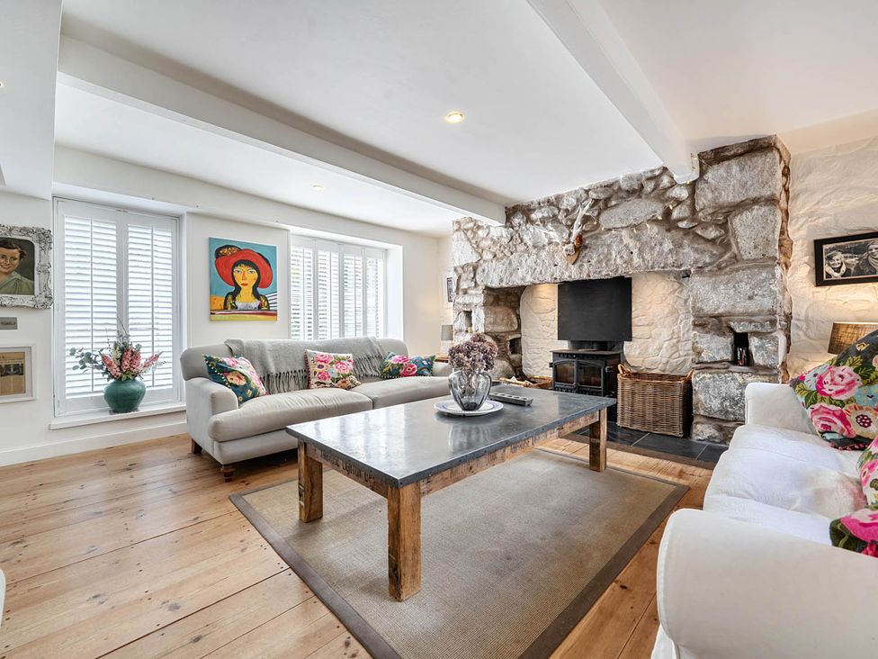 A living room with a sofa, coffee table, and fireplace at House Sleeps 6 Pet Friendly Parking, Auchencairn near Palnackie