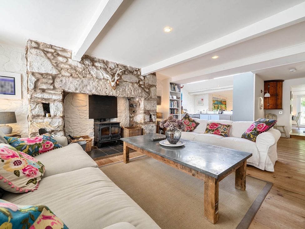 A living room with a fireplace and sofa at House Sleeps 6 Pet Friendly Parking in Auchencairn near Palnackie