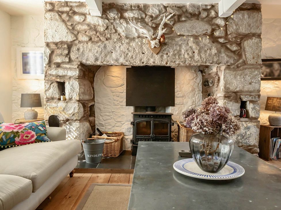 A living room with a fireplace and a coffee table at House Sleeps 6 Pet Friendly Parking Auchencairn near Palnackie