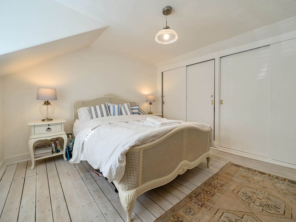 A bedroom with a bed and bedside table at House Sleeps 6 Pet Friendly Parking Auchencairn near Palnackie