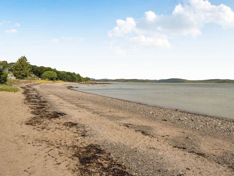A beach with sand and water near trees at House Sleeps 6 Pet Friendly Parking Auchencairn near Palnackie