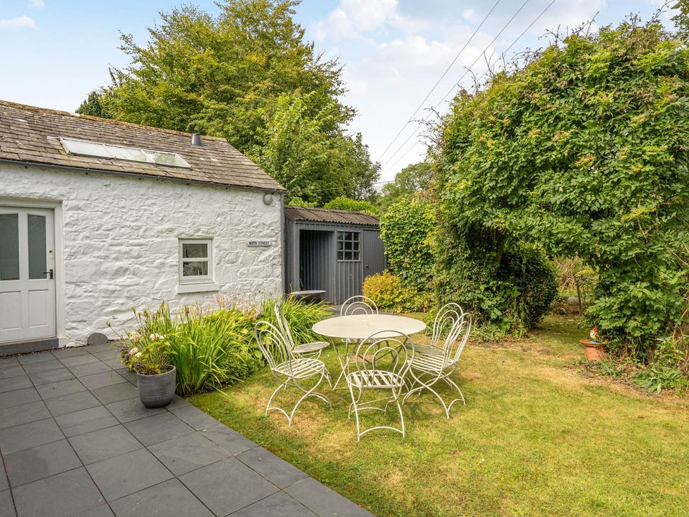 A garden with a table and chairs at House Sleeps 6 Pet Friendly Parking in Auchencairn near Palnackie