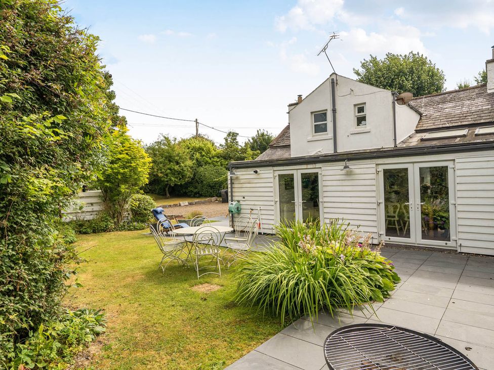 A garden with a patio table and chairs at House Sleeps 6 Pet Friendly Parking Auchencairn near Palnackie
