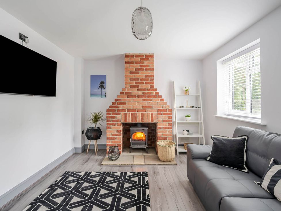 A living room with a fireplace and a sofa at Detached House in Quiet Village Pets Allowed Ashbocking near Otley, Suffolk