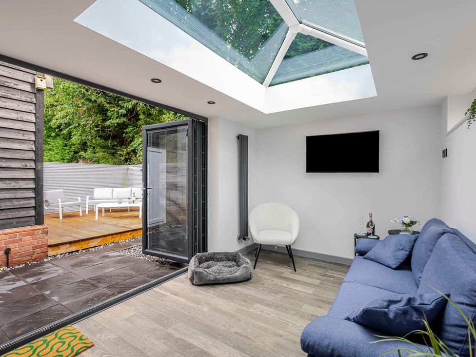 A snug area with a sofa and television at Detached House in Quiet Village Pets Allowed Ashbocking near Otley, Suffolk