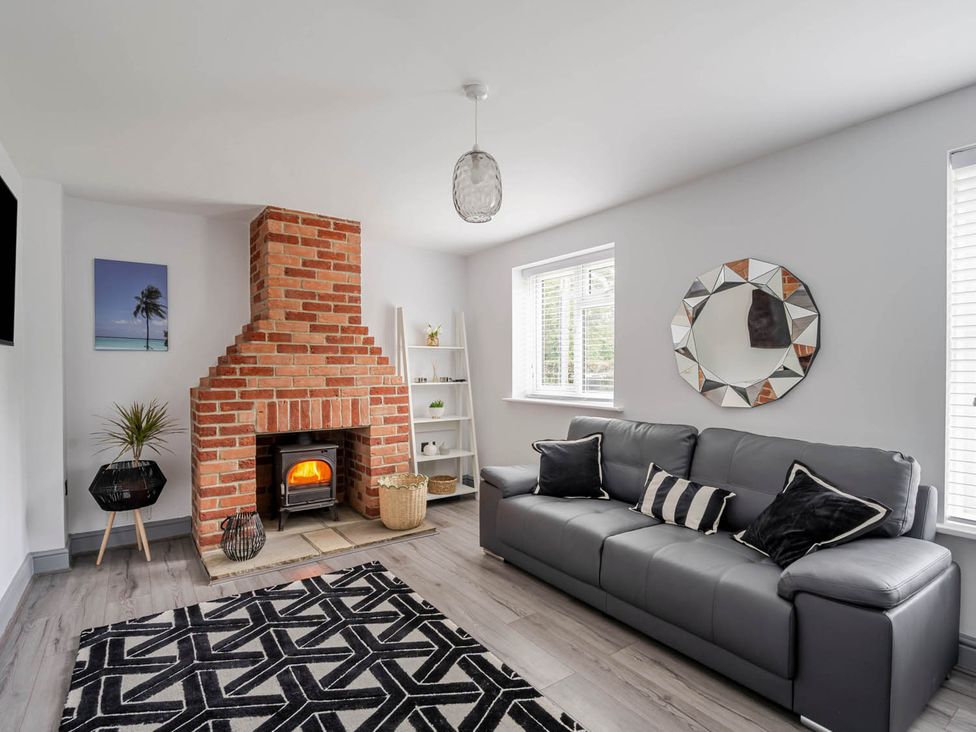 A living room with a fireplace and sofa at Detached House in Quiet Village Pets Allowed Ashbocking near Otley, Suffolk
