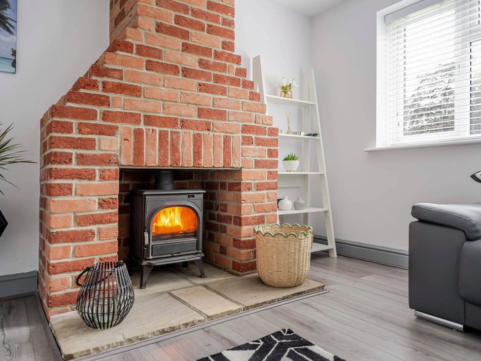 A living room with a brick fireplace and stove at Detached House in Quiet Village Pets Allowed Ashbocking near Otley Suffolk