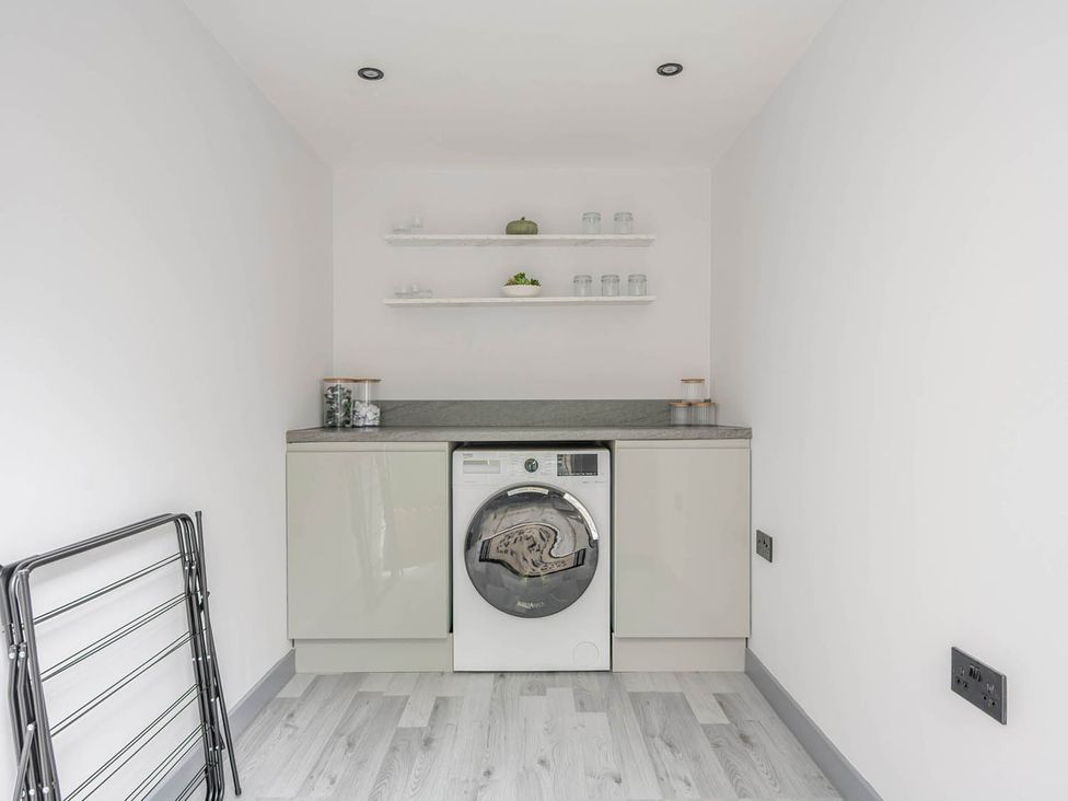 A laundry room with a washing machine and countertop at Detached House in Quiet Village Pets Allowed, Ashbocking near Otley, Suffolk