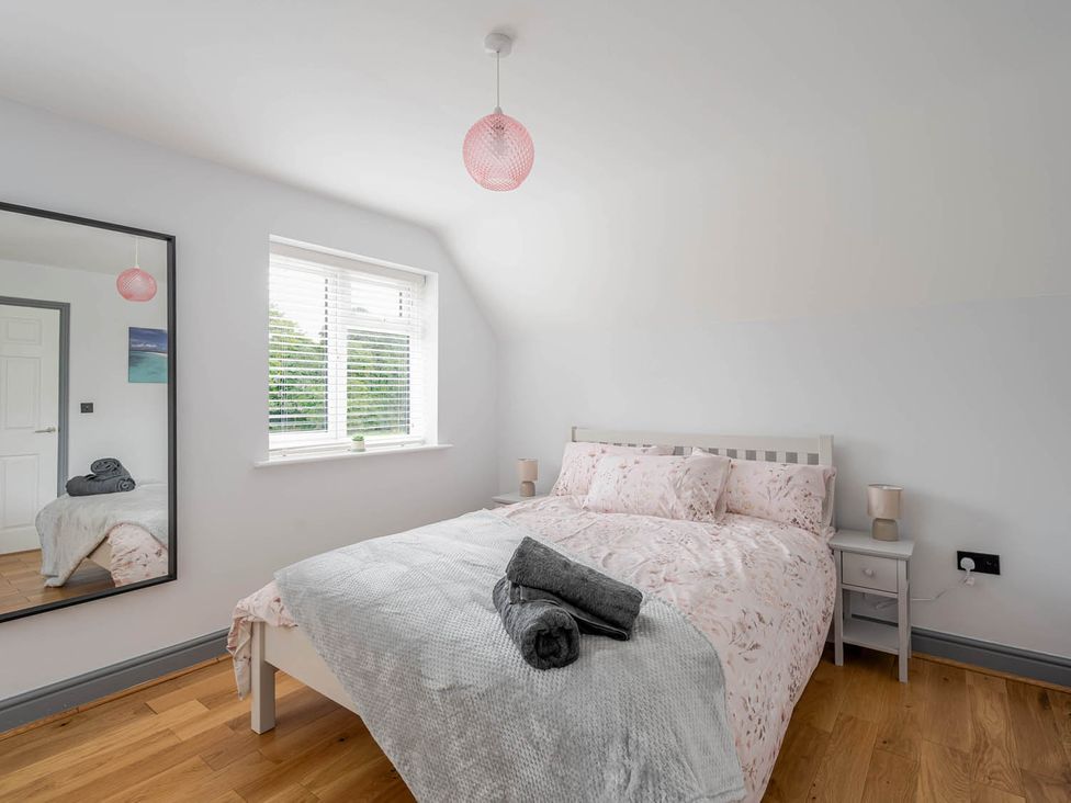 A bedroom with a bed and mirror at Detached House in Quiet Village Pets Allowed Ashbocking near Otley, Suffolk