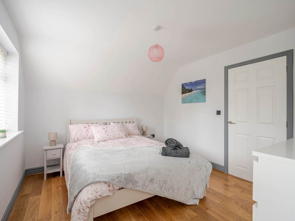 A bedroom with a bed and bedside table at Detached House in Quiet Village Pets Allowed Ashbocking near Otley, Suffolk
