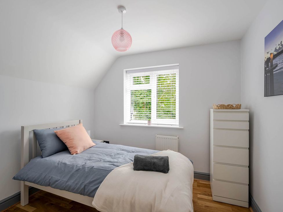 A bedroom with a bed and window at Detached House in Quiet Village Pets Allowed Ashbocking near Otley, Suffolk