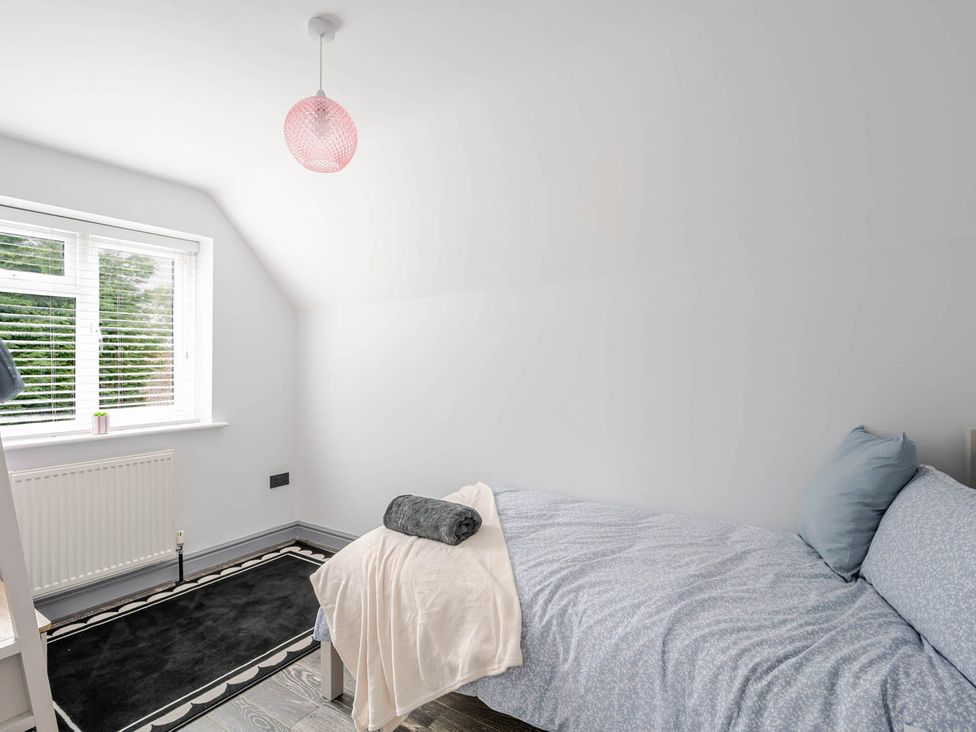 A bedroom with a bed and window at Detached House in Quiet Village Pets Allowed Ashbocking near Otley, Suffolk