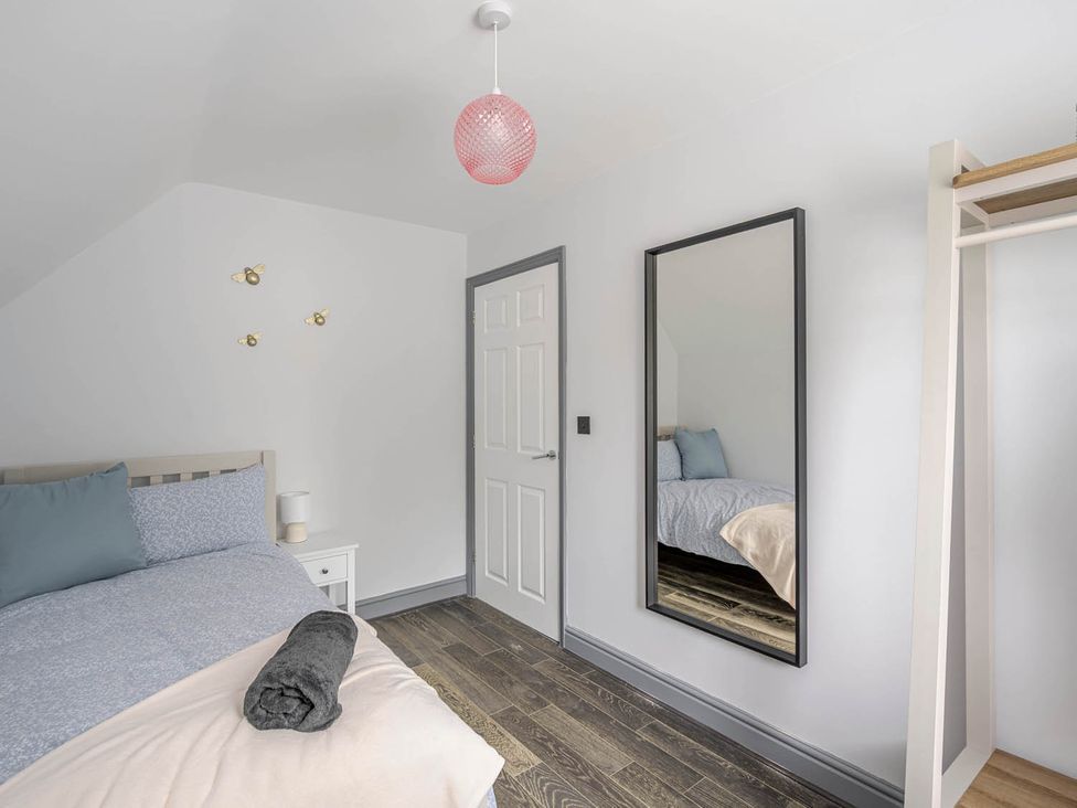 A bedroom with a bed and a mirror at Detached House in Quiet Village Pets Allowed Ashbocking near Otley, Suffolk