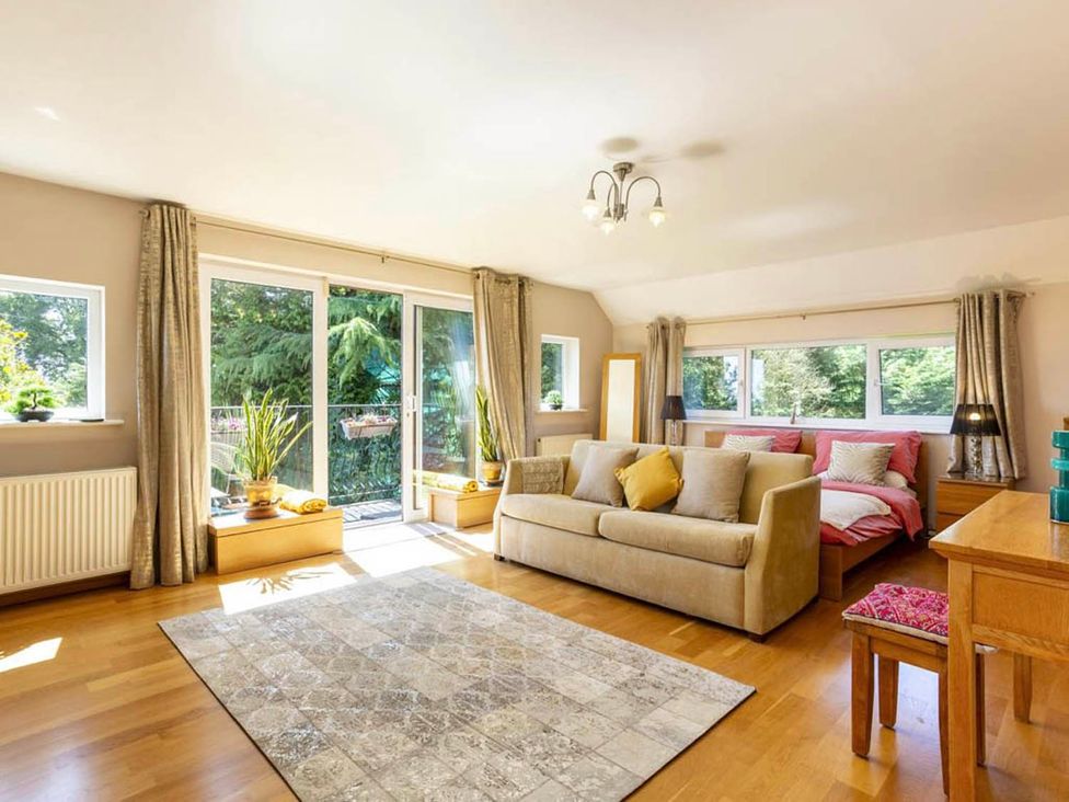 A living room with a sofa and plants at Sleeps 10 to 18 Parking Garden Pool Hot Tub Balcony in Friston