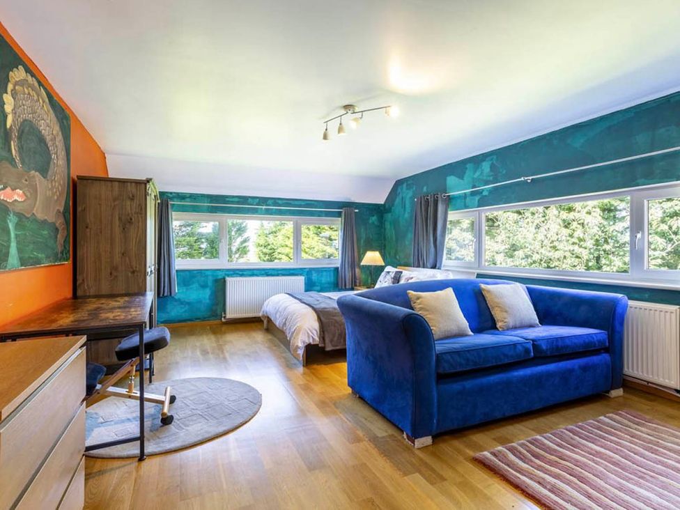 A bedroom with a blue sofa and desk at Sleeps 10 to 18 Parking Garden Pool Hot Tub Balcony Friston