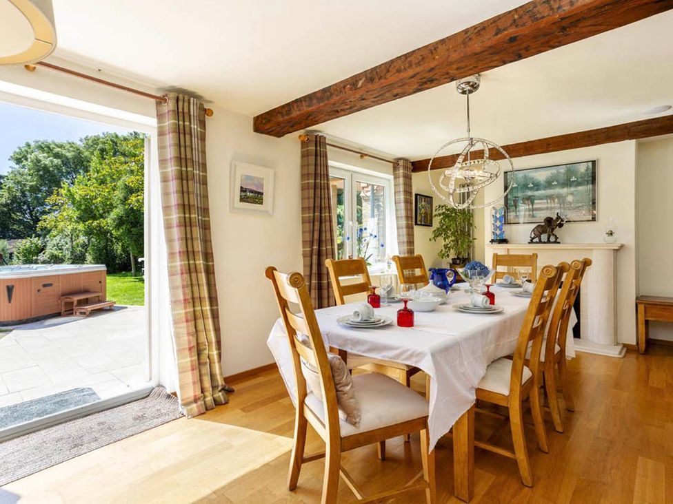 A dining room with a table set for dinner at Sleeps 10 to 18 Parking Garden Pool Hot Tub Balcony in Friston