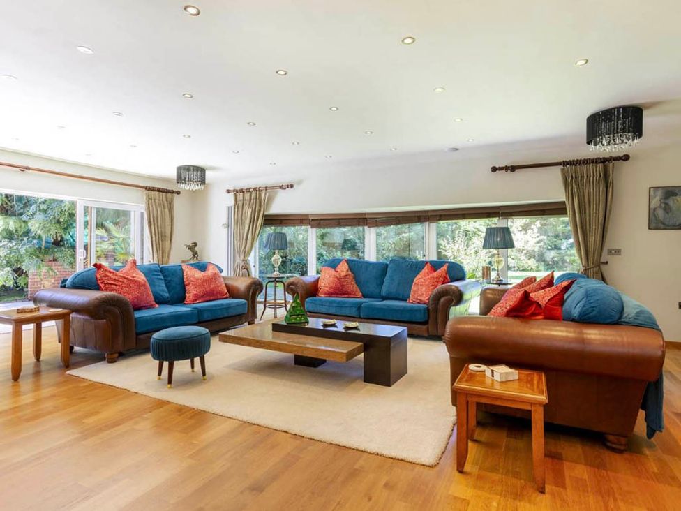 A living room with blue sofas and a coffee table at Sleeps 10 to 18 Parking Garden Pool Hot Tub Balcony Friston