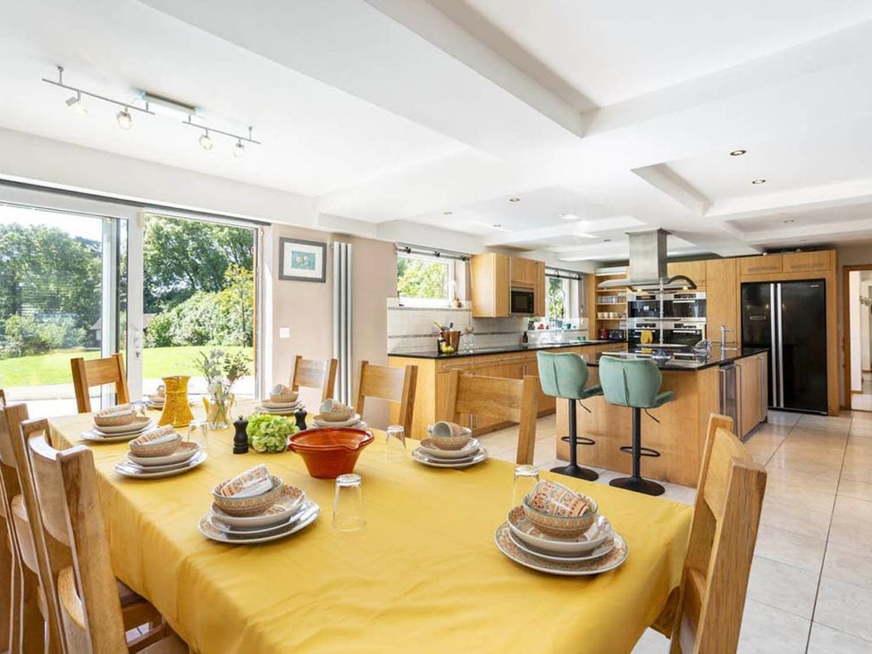 A kitchen with a dining table set for meals at Sleeps 10 to 18 Parking Garden Pool Hot Tub Balcony in Friston