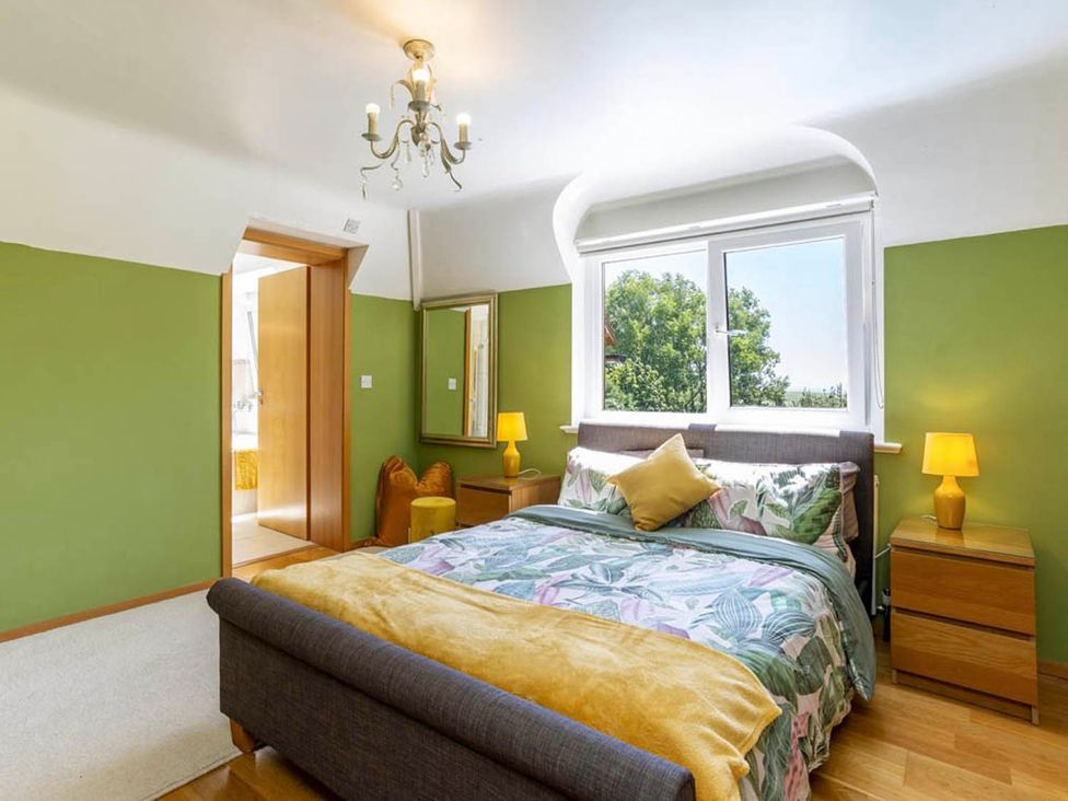 A bedroom with a bed and nightstands at Sleeps 10 to 18 Parking Garden Pool Hot Tub Balcony Friston