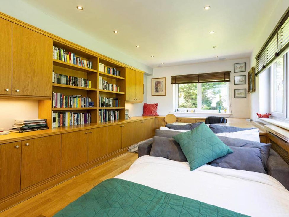 A bedroom with beds and a bookshelf at Sleeps 10 to 18 Parking Garden Pool Hot Tub Balcony in Friston