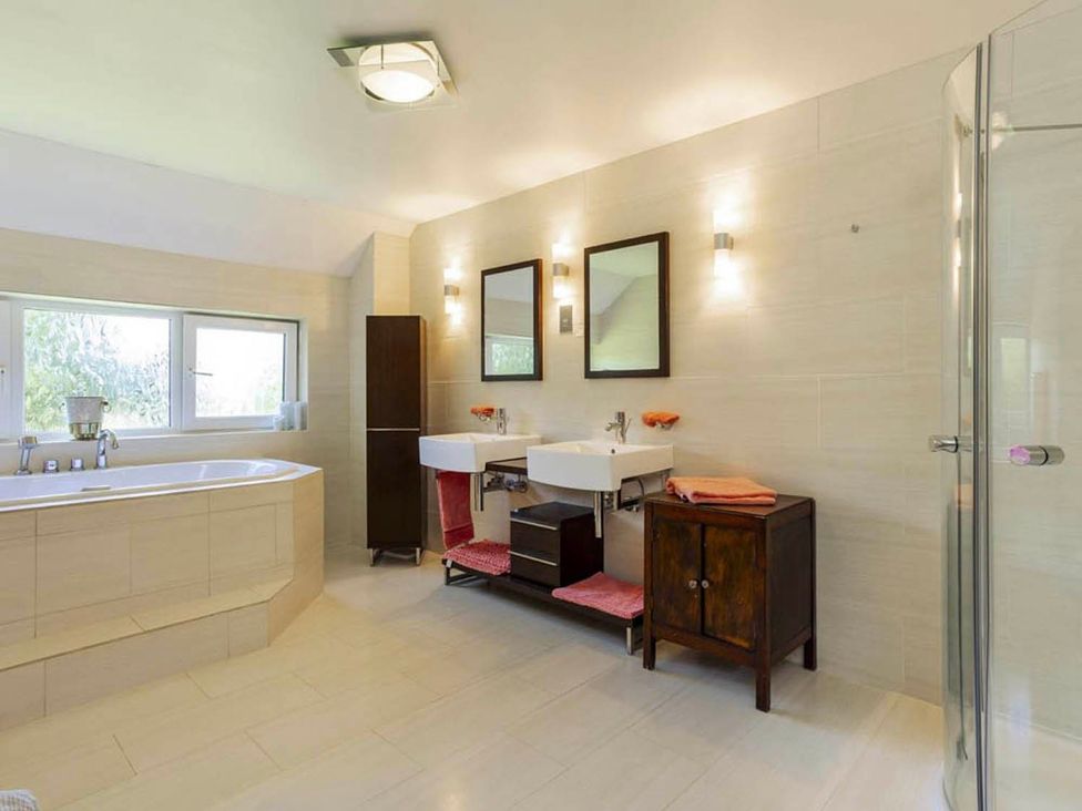A bathroom with a bathtub and sink at Sleeps 10 to 18 Parking Garden Pool Hot Tub Balcony in Friston