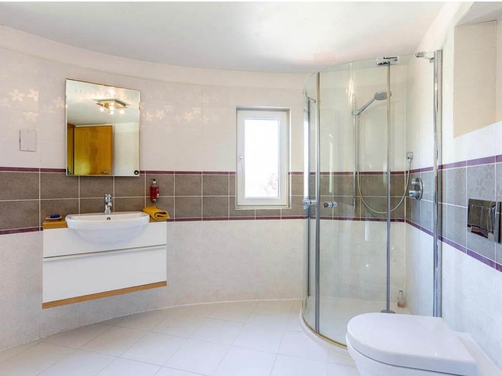 A bathroom with a sink shower and toilet at Sleeps 10 to 18 Parking Garden Pool Hot Tub Balcony in Friston