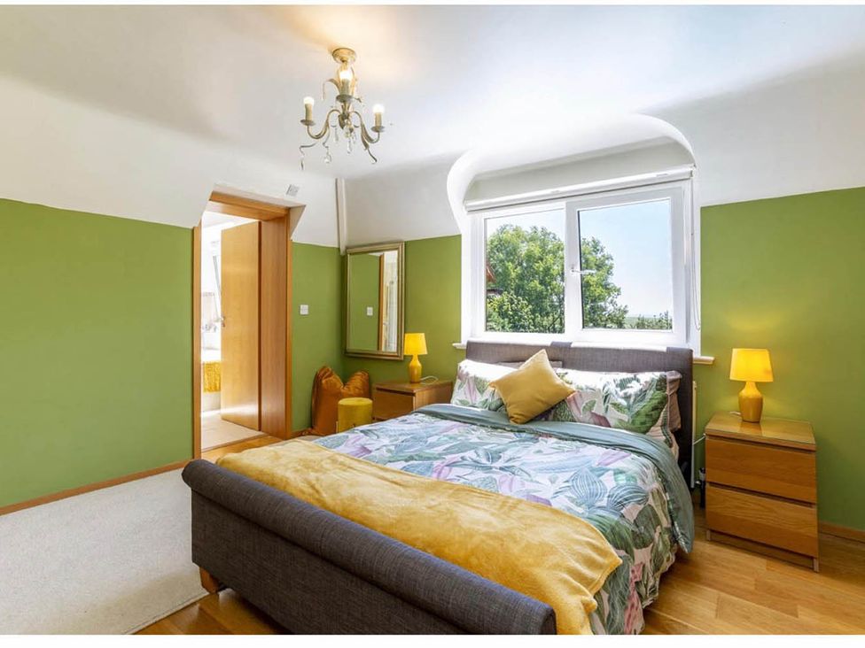 A bedroom with a bed and nightstand at Sleeps 10 to 18 Parking Garden Pool Hot Tub Balcony in Friston