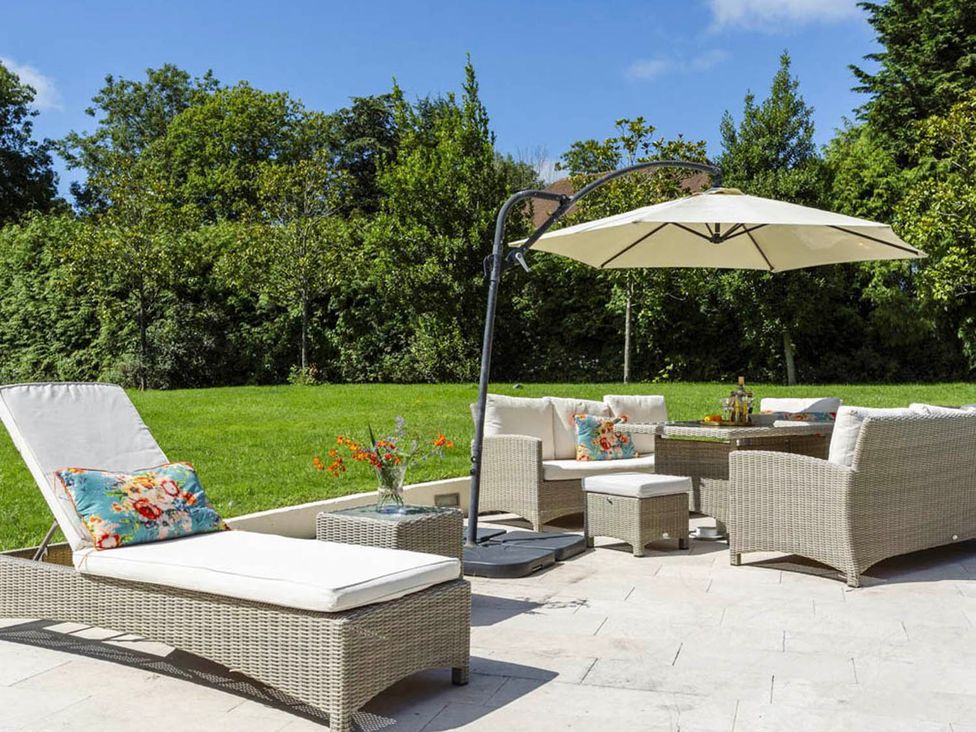 A garden with a sun lounger, outdoor table and chairs at Sleeps 10 to 18 Parking Garden Pool Hot Tub Balcony in Friston