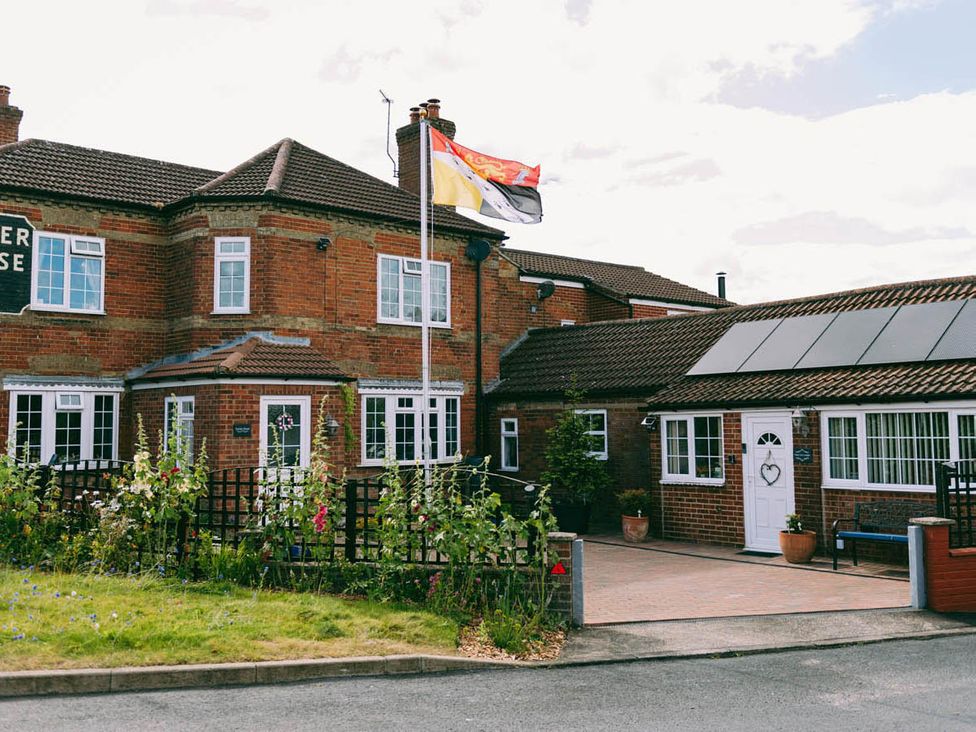 A building with a flag and garden at 1 Bed Sleeps 3 Free Parking Pets Allowed in Dereham