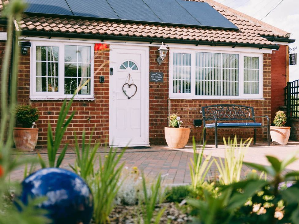 A front view of a house with a bench and flower planters at 1 Bed Sleeps 3 Free Parking Pets Allowed in Dereham