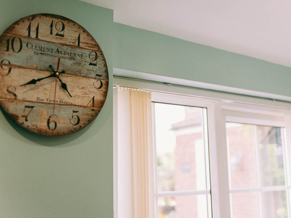 A clock on the wall and a window with a curtain at 1 Bed Sleeps 3 Free Parking Pets Allowed in Dereham