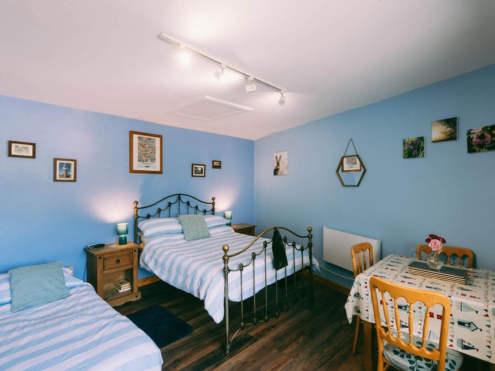 A bedroom with two beds and a table at 1 Bed Sleeps 3 Free Parking Pets Allowed in Dereham