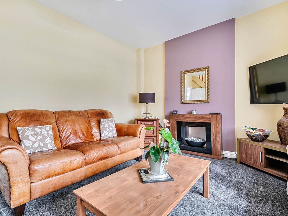 A living room with a sofa, coffee table, and television at Cottage Sleeps 6 with Parking and Garden in Bridlington